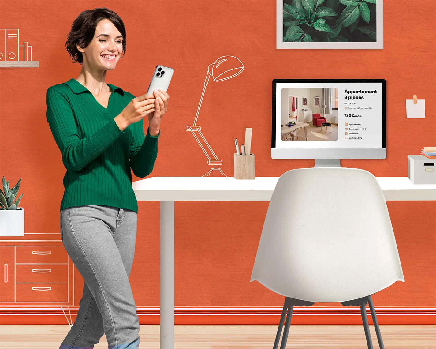 Femme souriante consultant son téléphone devant un bureau avec un écran d’ordinateur affichant une annonce immobilière